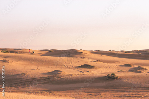 Couple in love standing in the Sahara desert at sunset