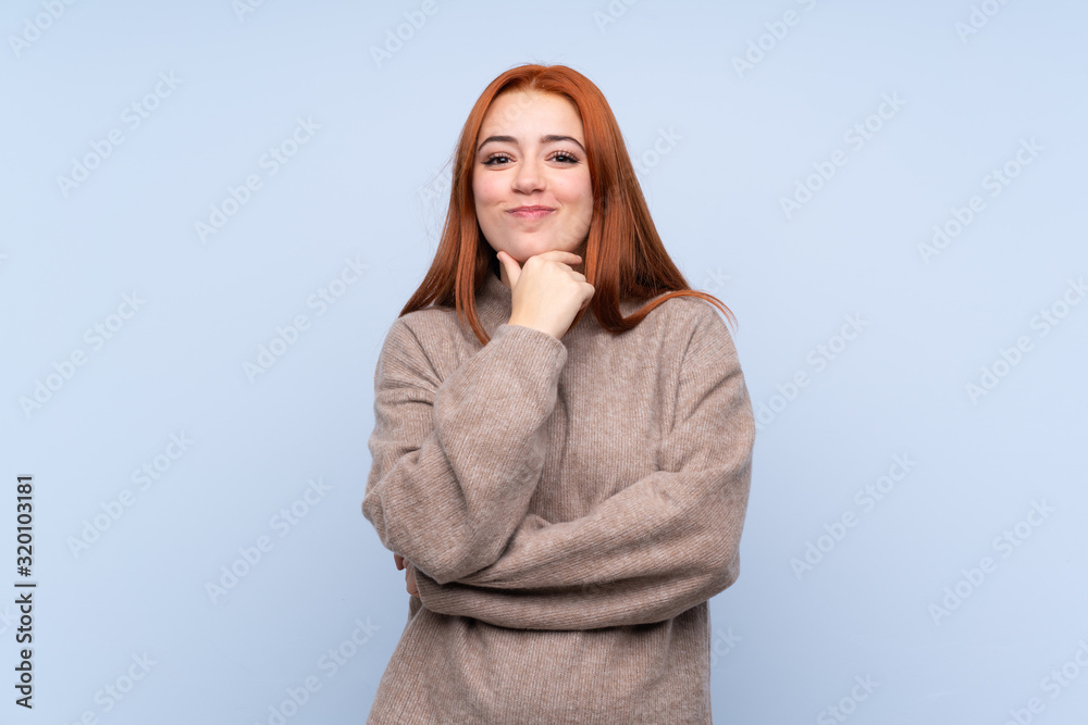 Redhead teenager girl with sweater over isolated blue background laughing Redhead teenager girl with sweater over isolated blue background laughing