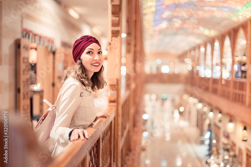 Tourist woman wearing turban scarf shopping in vintage Dubai market © EdNurg