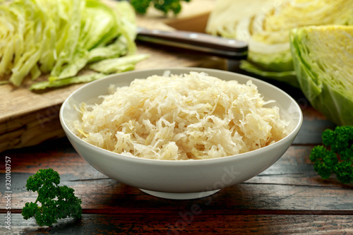 Foto Fresh pickled cabbage in white bowl on wooden table. healthy food