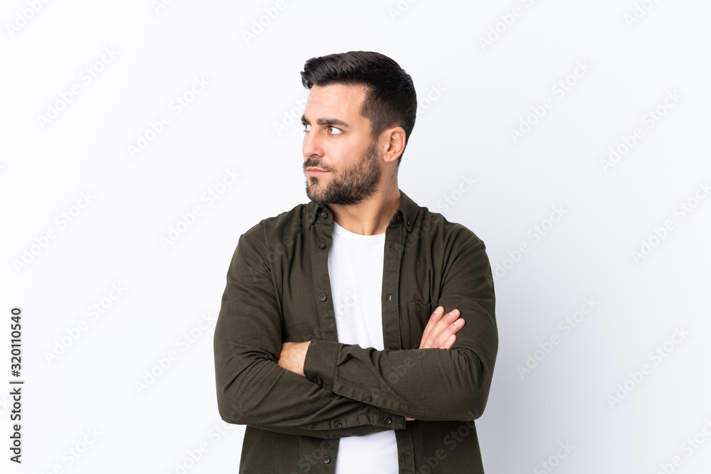 Young handsome man with beard over isolated white background portrait