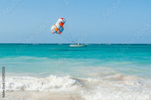 Sea foam and parasailing boat on horizon