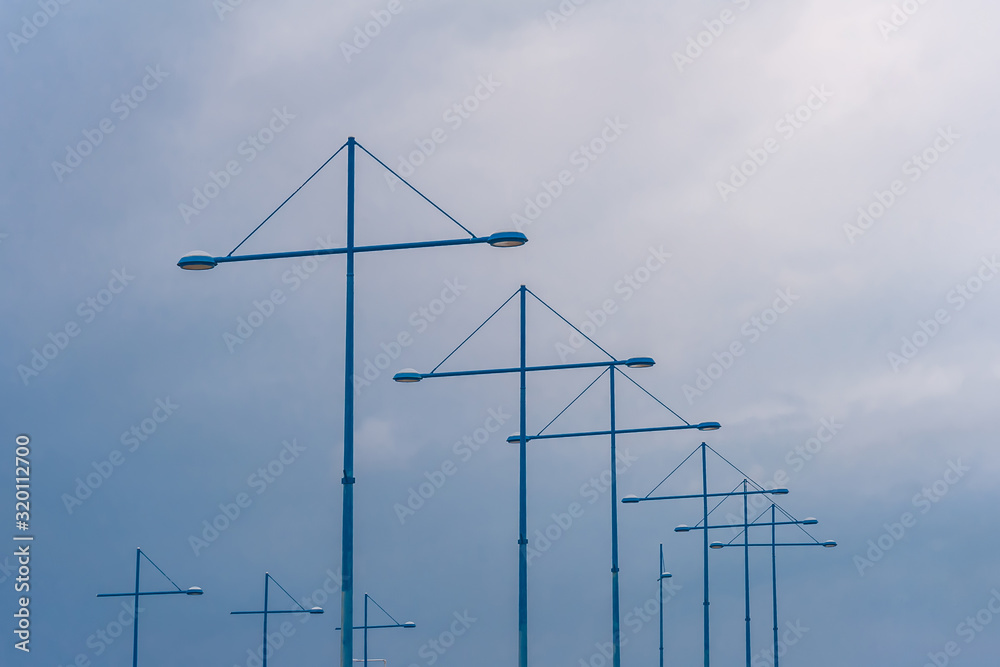 Fototapeta premium Lampposts in the port against the sky and clouds
