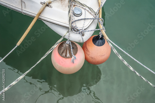 Feed of a ship with red balls reflected in water photo