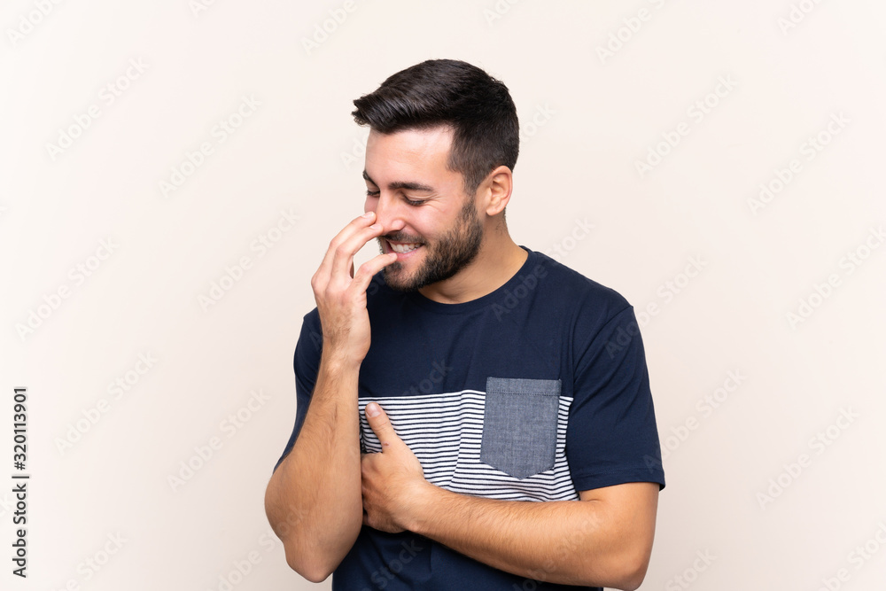 Young handsome man with beard over isolated background smiling a lot