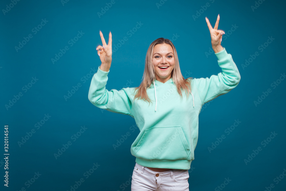 Happy girl smiling, portrait in Studio on blue background. Positive young blond woman Happy girl smiling, portrait in Studio on blue background. Positive young blond woman