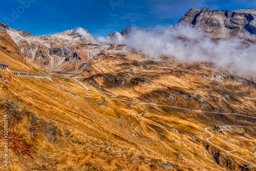 Low clouds sitting on the edge of the rocky ranges of the Alps in the autumn near the Grossglockner Peak in Carinthia, Austria