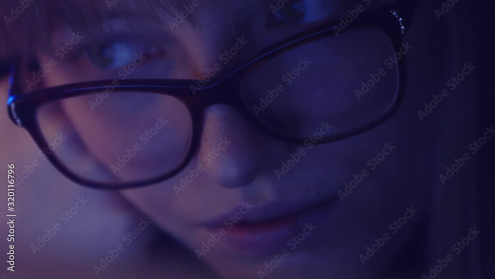 Freelance tired woman with glasses working late at night. IT specialist finishing work on the laptop. Deadlines and overworking concept workaholic