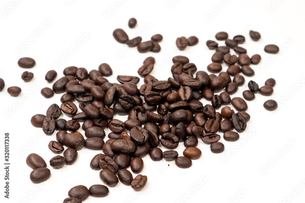 A handful of coffee beans on a white background A handful of coffee beans on a white background