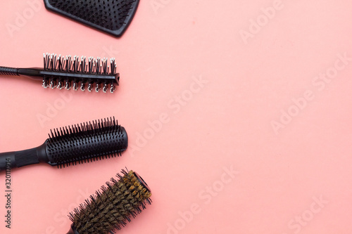 Collection of hairdresser's combs on the side on a pink background