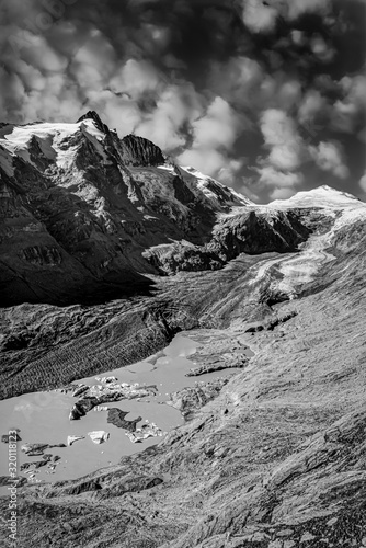 Black and white scene of the Pasterze Glacier and the Grossglockner Peak with high contrasty cloudy sky in the background
