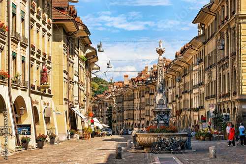Bern, Switzerland - August 31, 2016: People at Kreuzgassbrunnen in Kramgasse street with shopping area in old city center of Bern, Switzerland