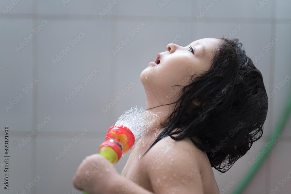 Fototapeta premium Beautiful little girl taking a shower bath.