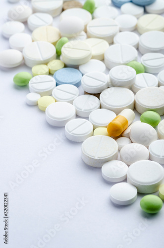 tablets of different shapes and colors on a white background close-up, soft focus, vertically