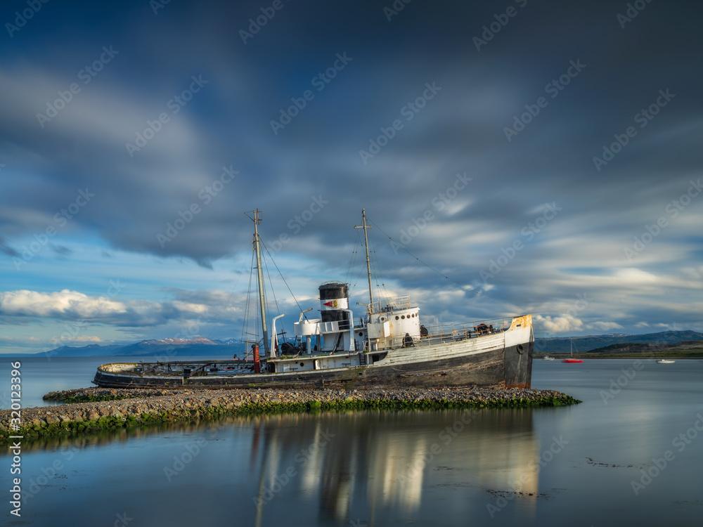 old tug Saint Christopher on pier under moving clouds in Ushuaia