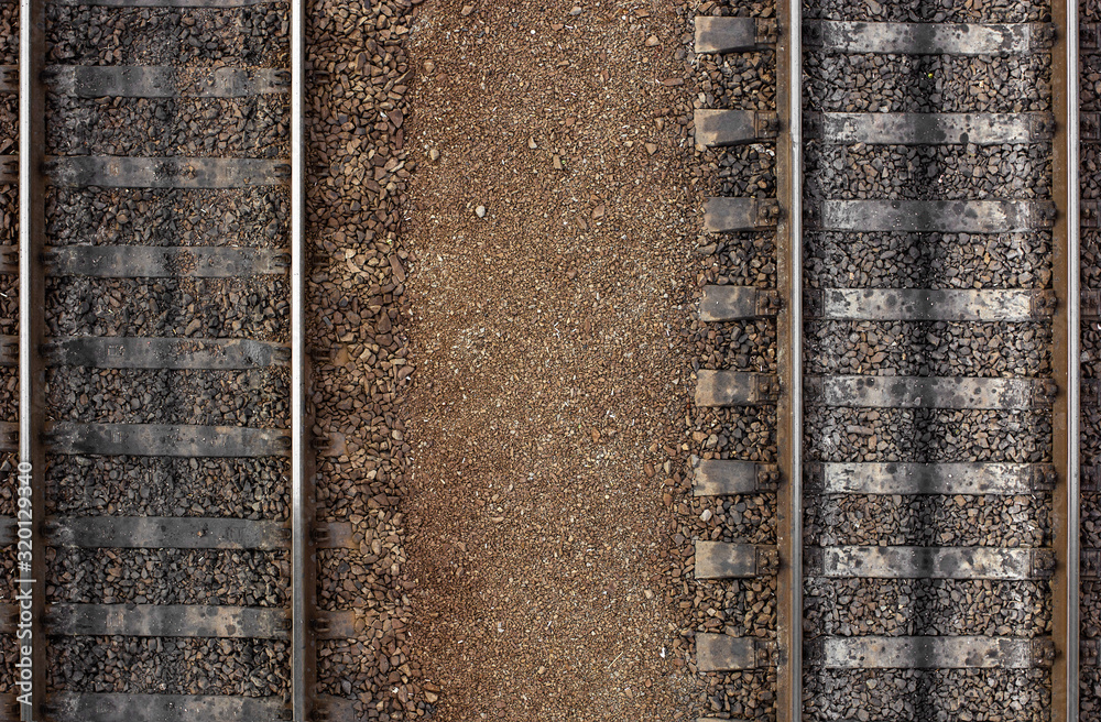 Railroad.Top view. Seamless railroad Pattern, backdrop with space for text. Shiny iron rails and concrete sleepers, coupled with powerful bolts on stony ground, fortified rubble. Railroad.Top view. Seamless railroad Pattern, backdrop with space for text. Shiny iron rails and concrete sleepers, coupled with powerful bolts on stony ground, fortified rubble.