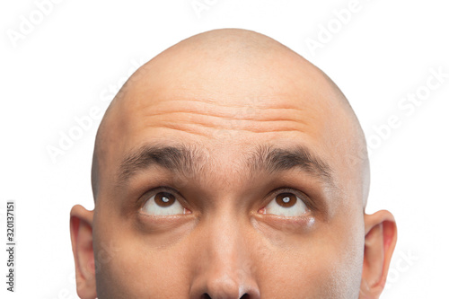 Image of bald man looking up, half head