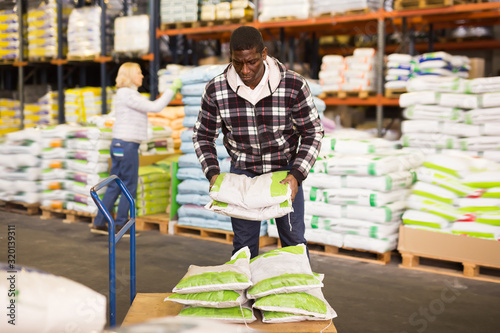Adult African American man stacking bags