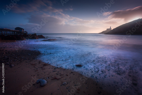 Sunrise over the Mumbles lighthouse and Mumbles pier in Swansea, UK