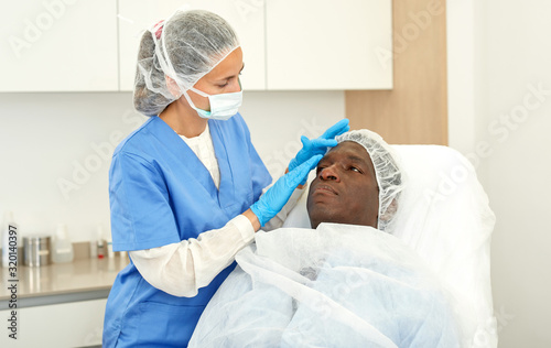 Professional  woman doctor examining patient before procedure in clinic