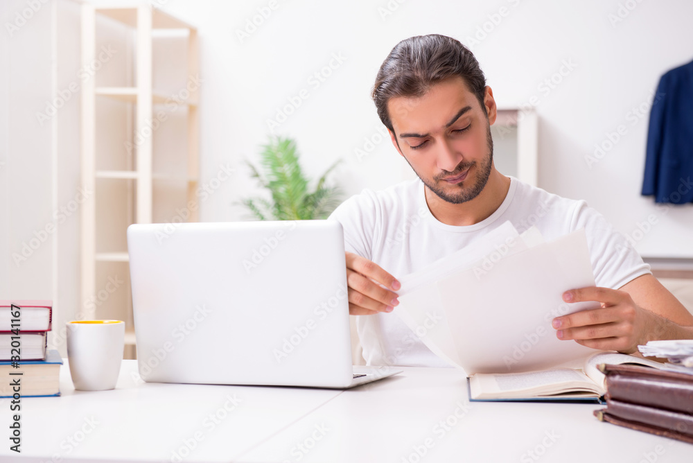 Young male student preparing for exams at home Young male student preparing for exams at home