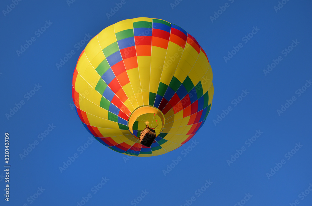 Fototapeta premium multi-colored hot air balloon against the blue sky 