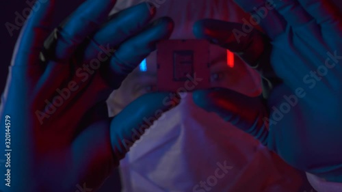 Scientist completed a scientific experiment in electronics. Silicon electronic chip in the hands of a researcher in lablaboratory. Engineer testing experimental innovation in cyber technology industry photo