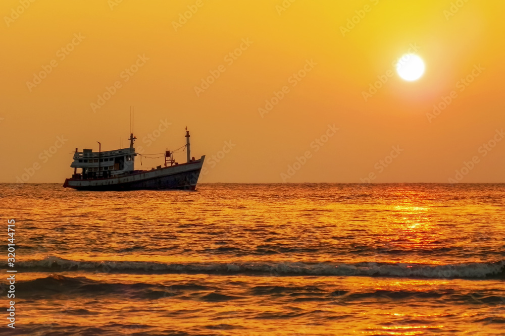Fishing boat at sea on the horizon during sunset Fishing boat at sea on the horizon during sunset