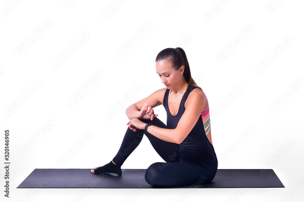 Beautiful sporty girl looks at her smart watch, on a white background.Healthy lifestyle concept.Copy space Beautiful sporty girl looks at her smart watch, on a white background.Healthy lifestyle concept.Copy space