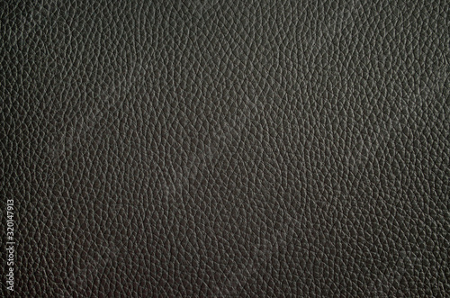 Leather texture close up. Black fashionable background, top view. Stylish wallpaper of gray color. Rough surface.