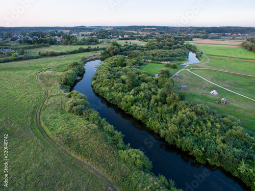 A beautiful sunny view of the forest, fields and river from above. Summer drone photography 