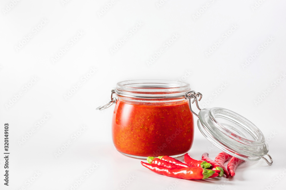 Hot chili pepper sauce paste harissa. Adjika. Traditional Tunisia, Georgian and Arabic cuisine. Homemade rose harissa in a glass jar. Hot chili pepper sauce paste harissa. Adjika. Traditional Tunisia, Georgian and Arabic cuisine. Homemade rose harissa in a glass jar.