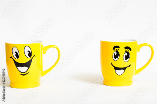 Relationshio concept with two happy yellow cups on white background
