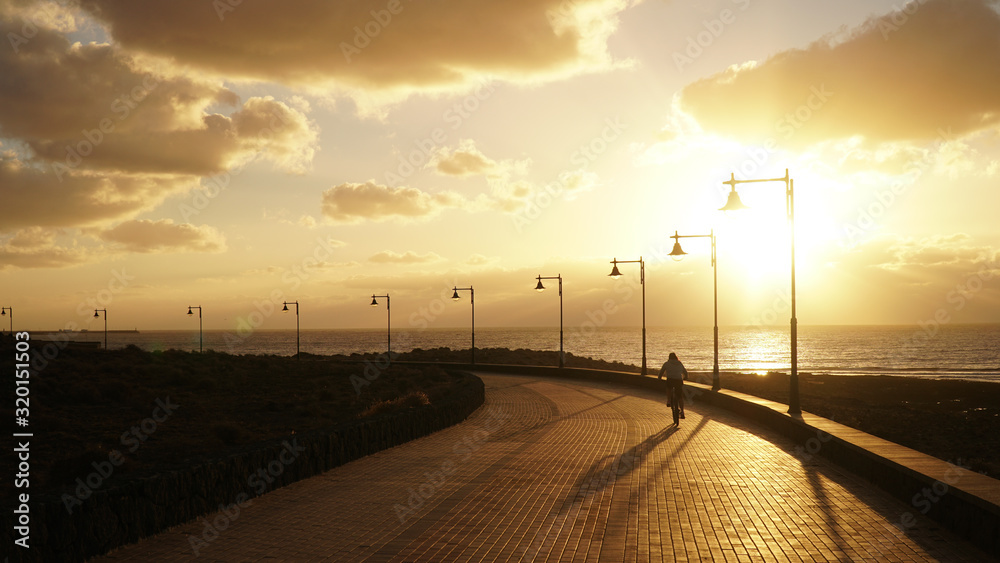 Sunset over the oceans with cloud cover and light beams on Lanzarote Island in Spain. 