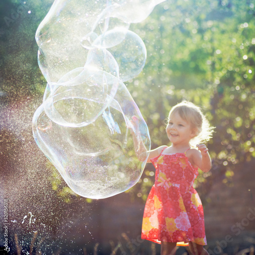 little girl playing with soap bubbles