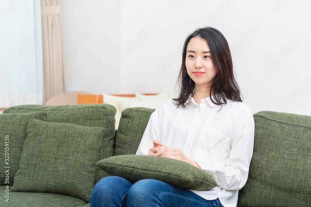 リビングのソファーに座る女性 リビングのソファーに座る女性