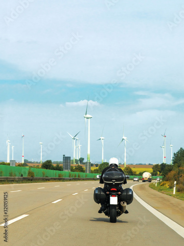 Motorbike and wind mils on the road in Switzerland.