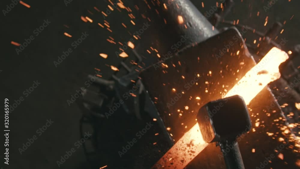 Forge workshop. Smithy manual production. Hands of smith with hammer hit on glowing hot metal, on the anvil, the forging process. Blacksmith makes iron products for manufacture of fireplace, stove.