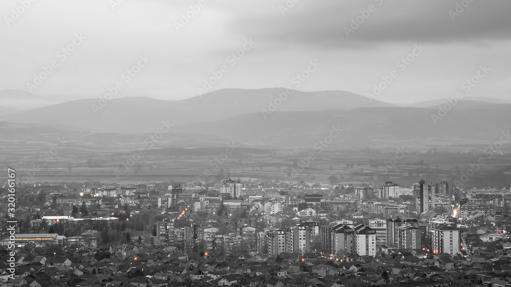 Fototapeta premium Beautiful desaturated Pirot cityscape, murky weather and distant mountains