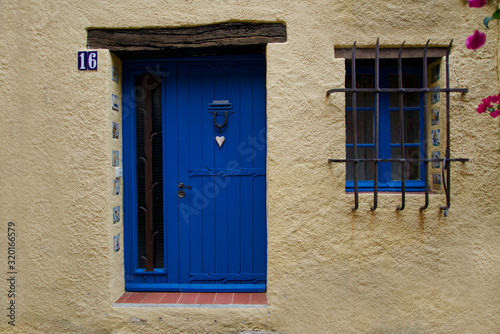 Fototapeta Naklejka Na Ścianę i Meble -  Blue door and blue window of a beige house