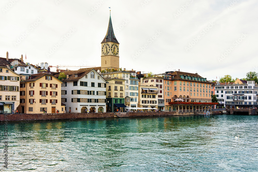 St Peter Church at Limmat River quay in the city center of Zurich, Switzerland. People on the background