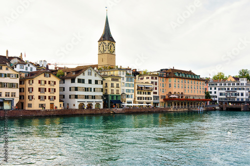 St Peter Church at Limmat River quay in the city center of Zurich, Switzerland. People on the background