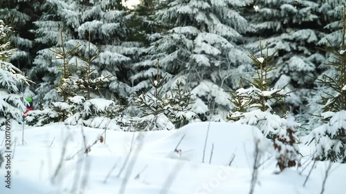 Unrecognizable skiers going up the hill in the forest on a chair lift in the background
