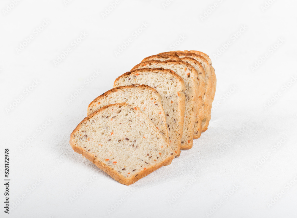 Whole grain fitness bread with dried carrots and flax, pumpkin, and sunflower seeds, sliced on a light background