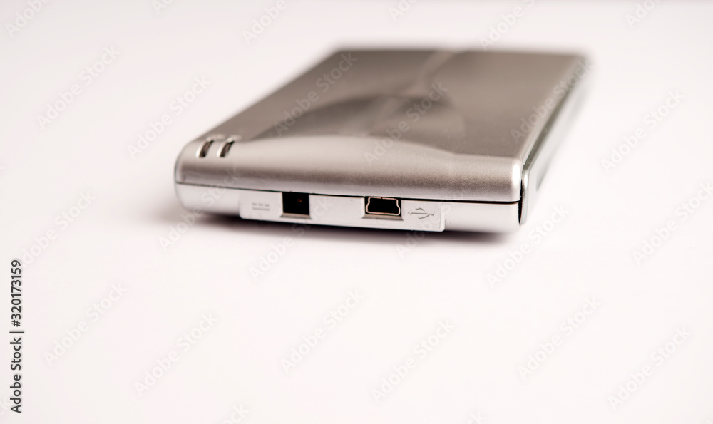 Small aluminum gray hard disk, with front loading connections and mini usb connection on white background Small aluminum gray hard disk, with front loading connections and mini usb connection on white background