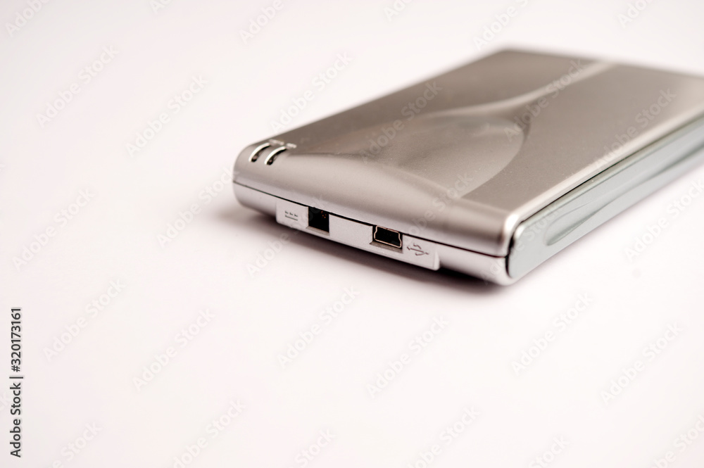 Small aluminum gray hard disk, with front loading connections and mini usb connection on white background
