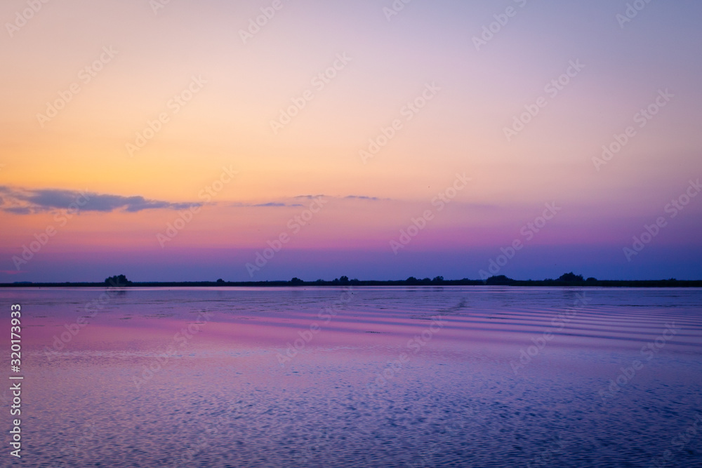 Sailing through beautiful areas of Danube Delta unique landscape at sunset