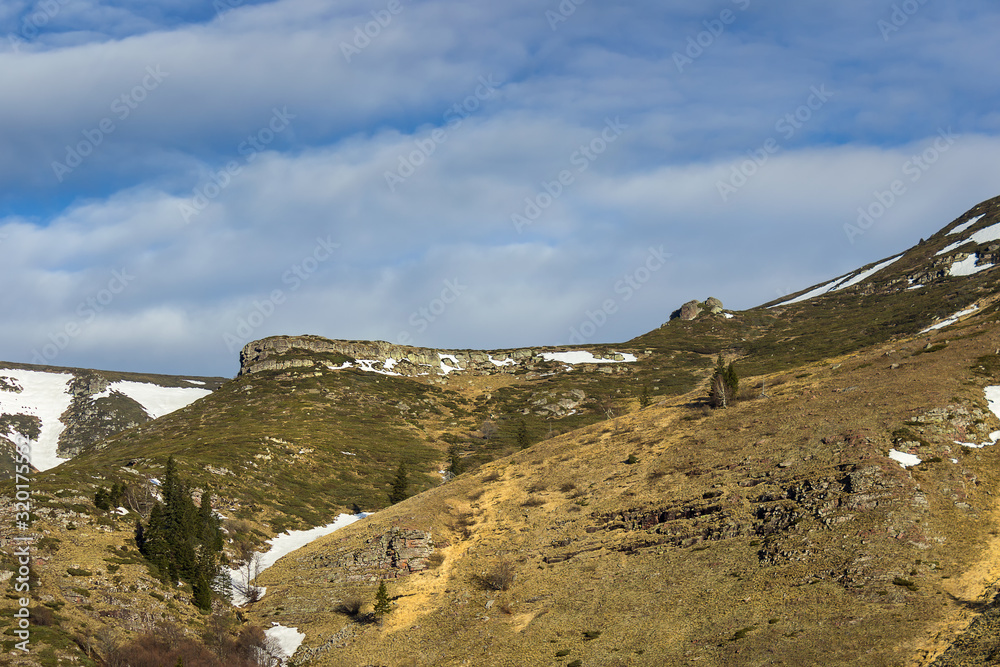 Amazing, rocky, alien highlands of juniper covered Old mountain and transition from winter to spring season Amazing, rocky, alien highlands of juniper covered Old mountain and transition from winter to spring season