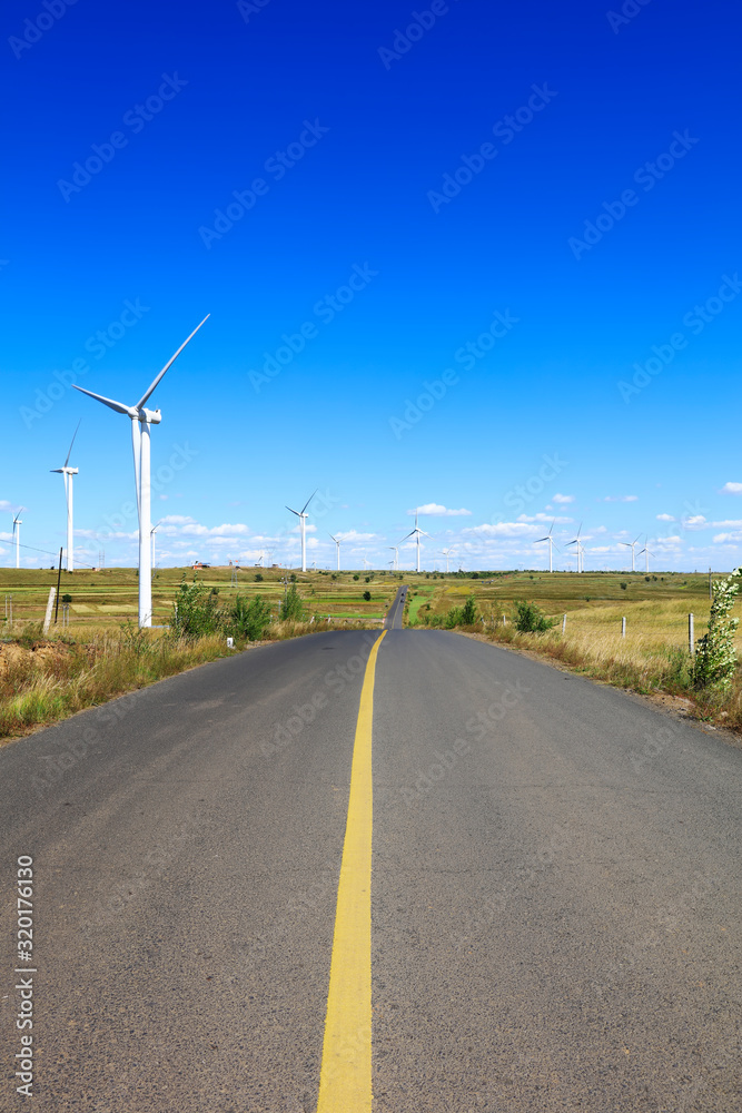 Fototapeta premium Asphalt road and wind turbines