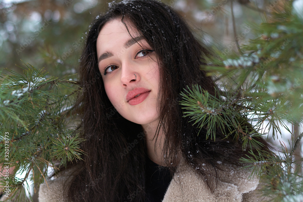 girl in a fur coat near Christmas trees in the winter forest girl in a fur coat near Christmas trees in the winter forest
